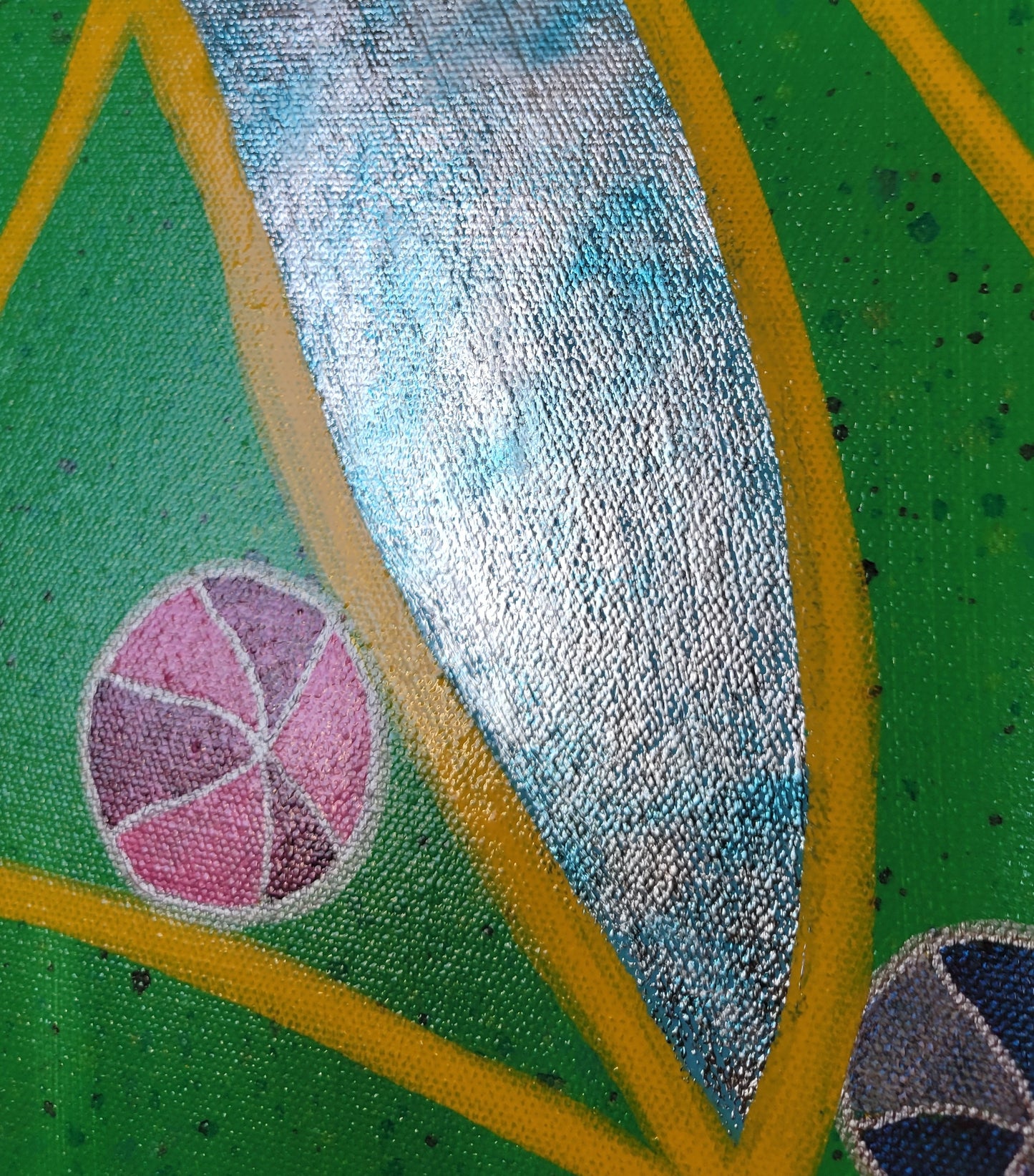 Close-up detail of the foil in the central area of the painting, showing how reflective the silver can be while also showing the blue of the sky peeking through in the foil. There is also a pink and magenta ball and a blue and silver ball nestled against yellow lines against the vibrant green background.