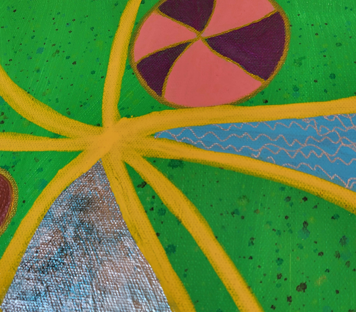 Another detailed look at the intersection of yellow lines that also show the foil from another angle along with the silver squiggly lines in another section of the painting, with a pink, violet, and gold ball nestled next to the yellow lines. This picture also shows the multi-colored speckling of the green background.