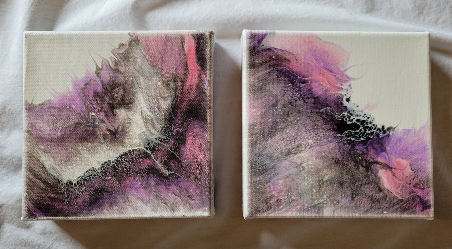 Two 6x6x1.5 in gallery wrapped canvases, both featuring fluid acrylic art in pinks, purples, grays, and blacks. The layers of color band, flow and layer in a way that resembles a nebula, particularly when the two canvases are oriented together, as if the fluid art poured out from a seam between the two.