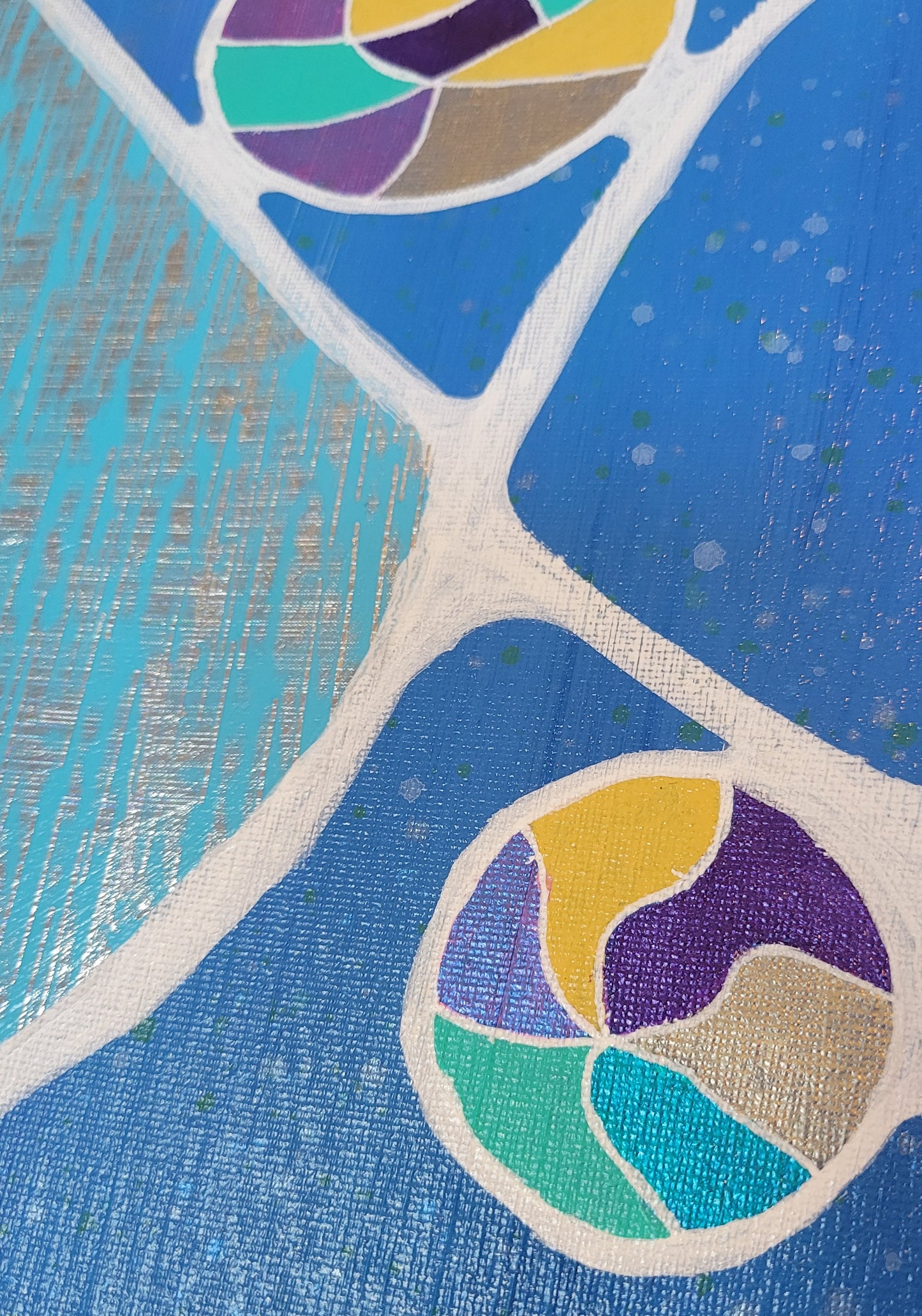 Close-up details of the multi-colored balls nestled against white lines. The sky blue with silver water-surface foil is more clearly seen, as are the white and yellow speckles on the dark blue background.