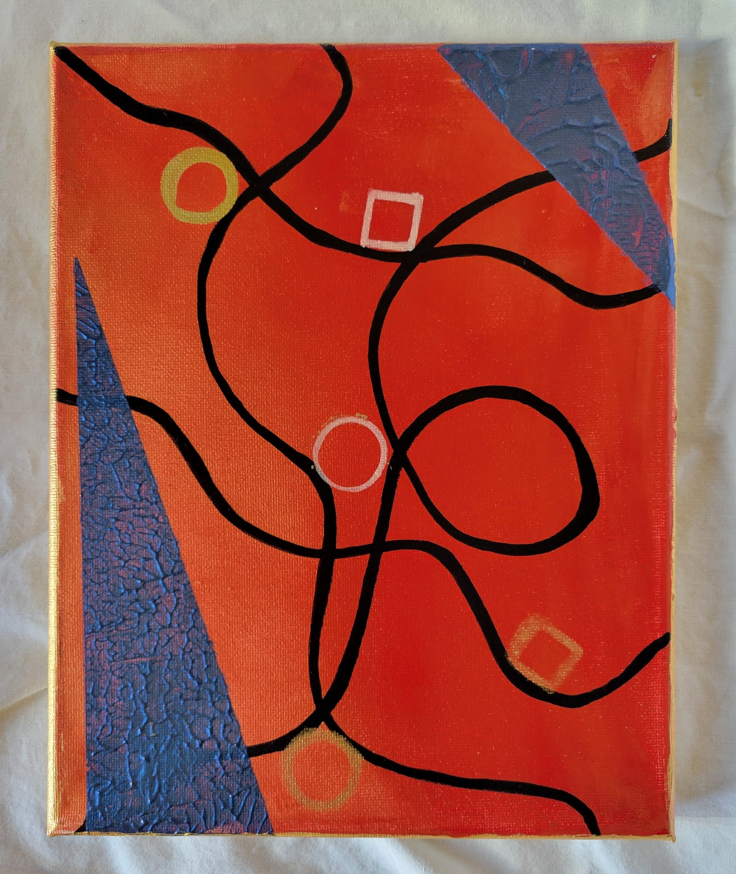 Black lines curve and curl over a golden red background of burning embers. Black-blue flames lick into the frame. Gold sparks and chalky ash float through the scene.