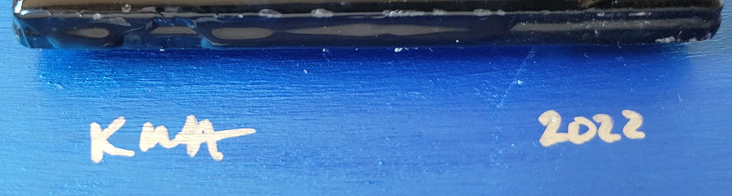 Close-up of the base of the tile against the royal blue background with the artist's initials "KMH" and year completed "2022".