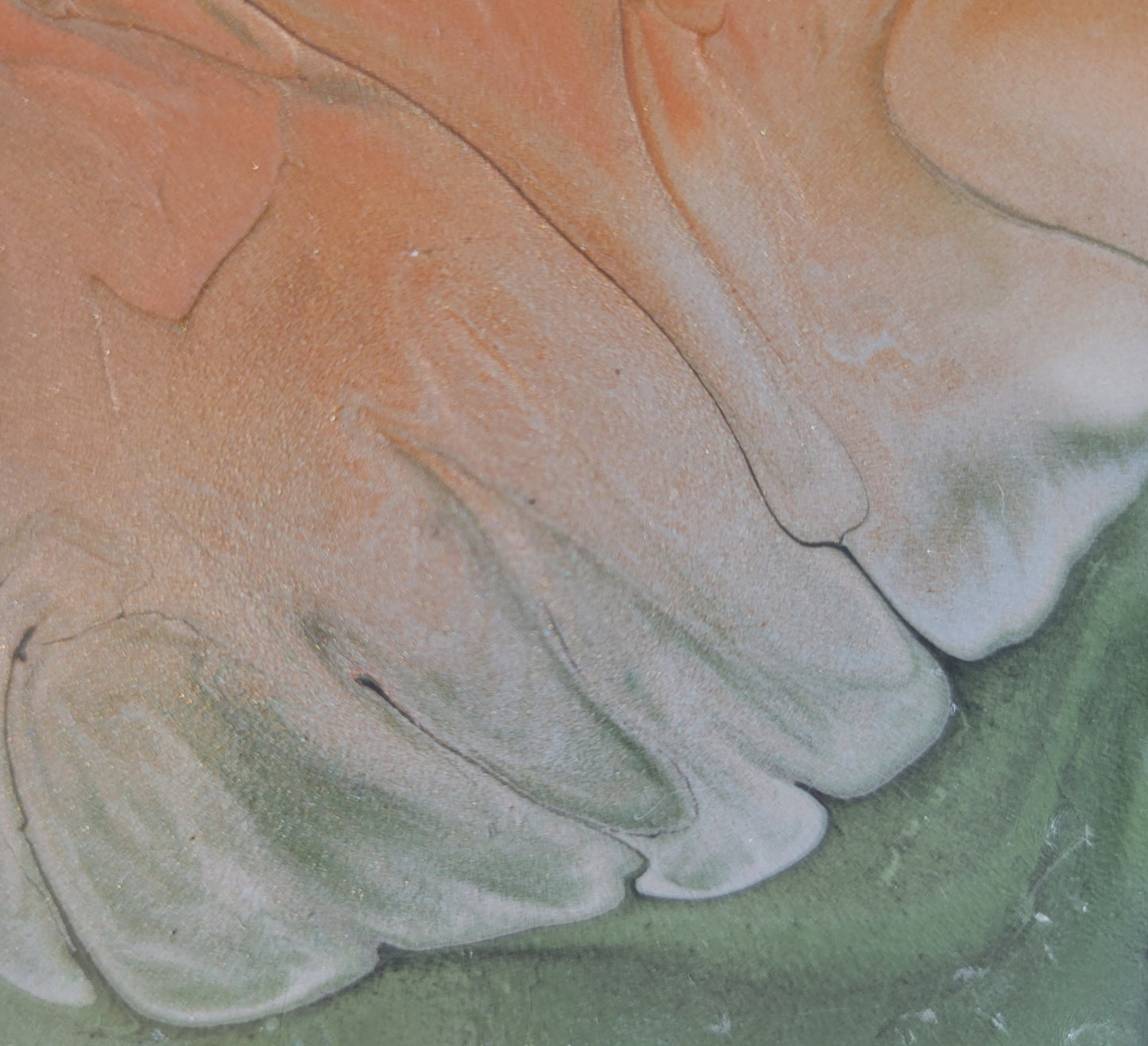 Close-up detail of a portion of the tile where the reddish copper intrudes into the green. The border is scalloped and bleeding into each other a bit. Some darker green or gray colors thread through the green and into the reddish bronze.