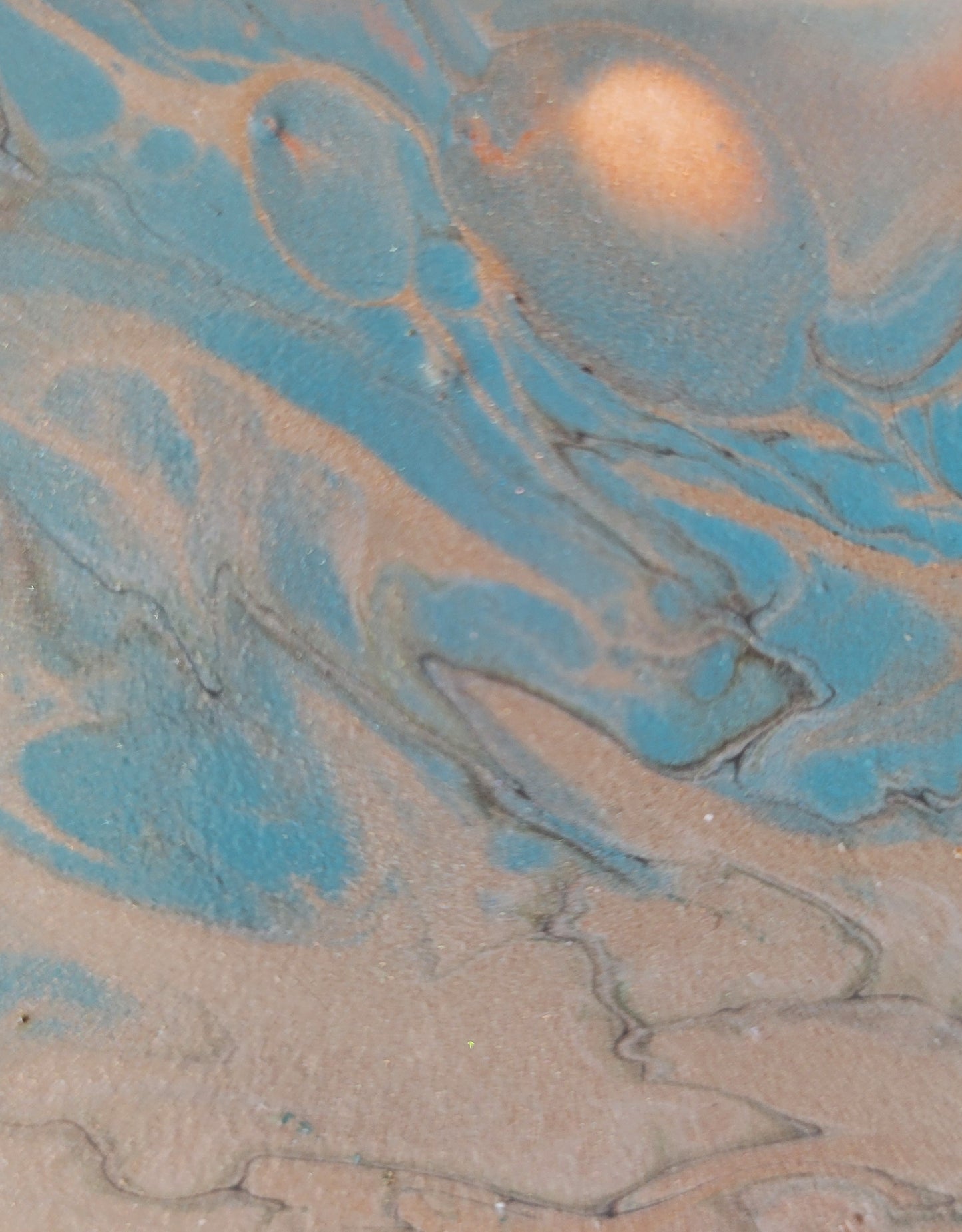 Close-up detail of section of the tile where the blue and reddish copper blend and swirl and bubble around each other, with dark gray threading through to highlight some of the boundaries.