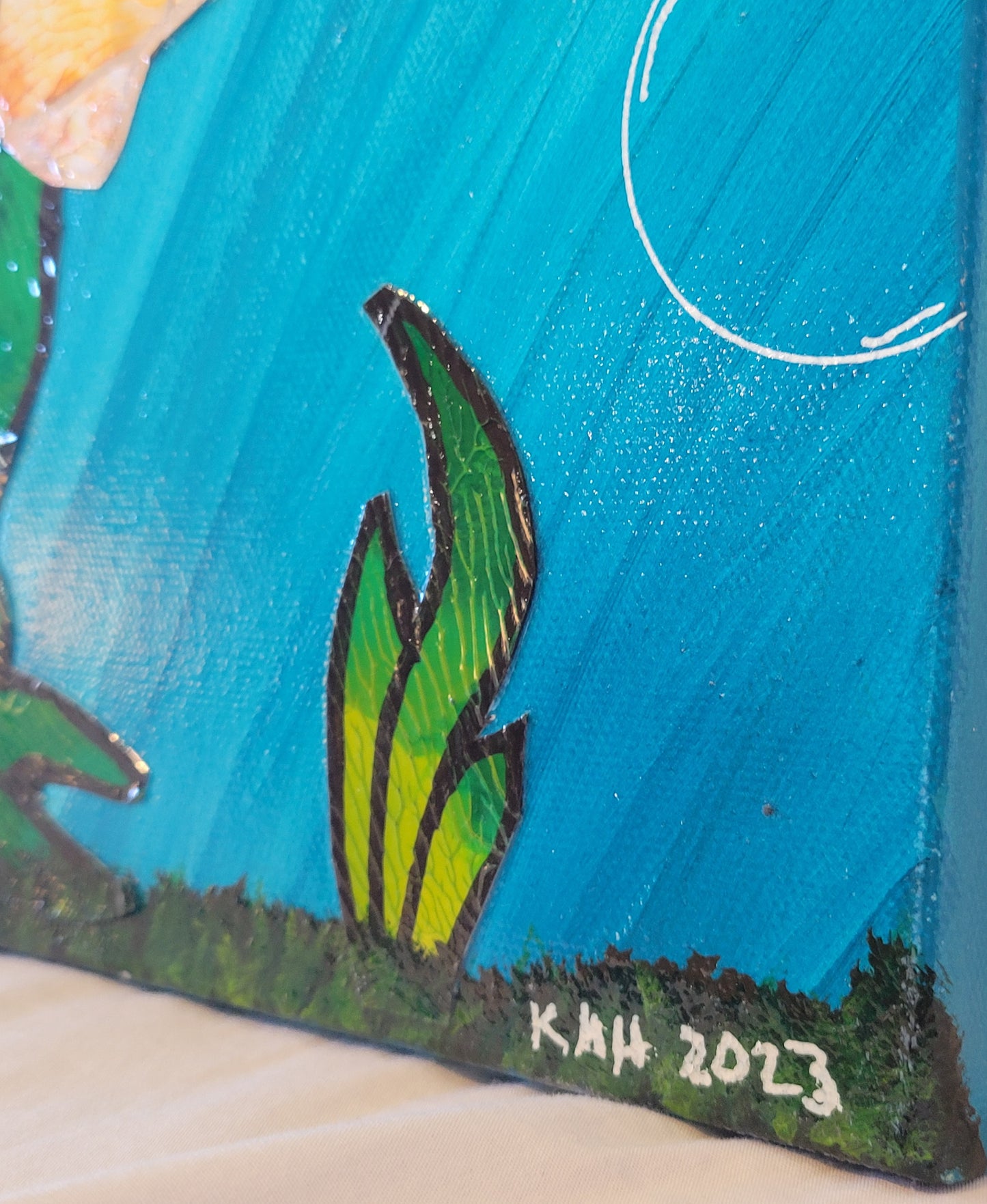 Angled close-up of the lower right corner of the painting showing a large air bubble and more textured seaweed resting on a bed of brown and green vegetation. Within that vegetation is written "KMH 2023" in white.