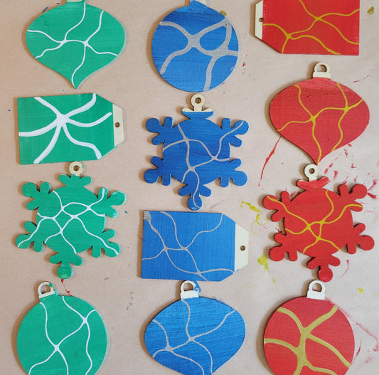 A series of painted wooden holiday ornaments in greens, blues, and reds. Each features neurographic line work.