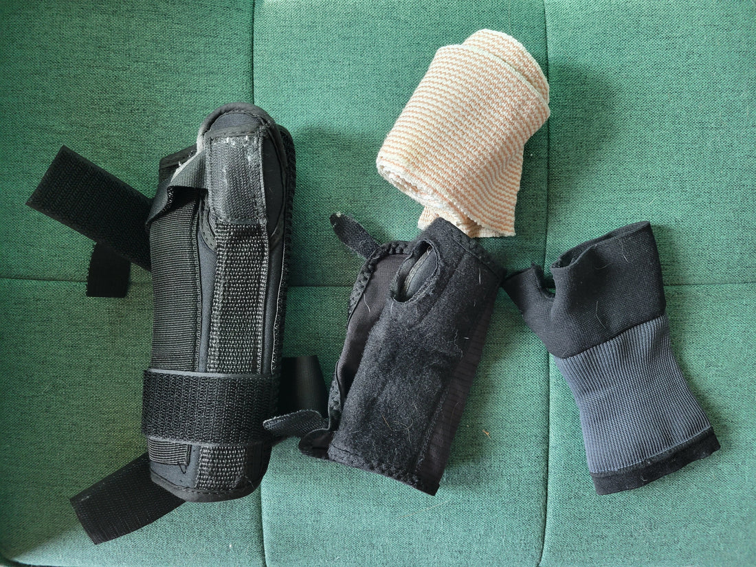 A collection of wrist guards, wraps, braces and supports on a green couch cushion.