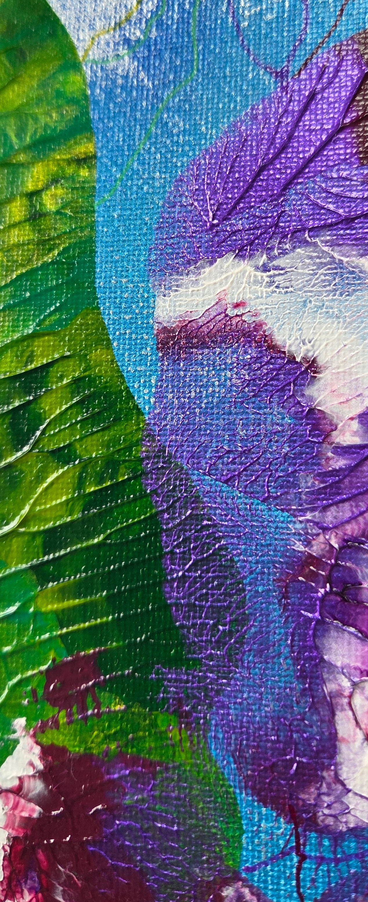 Close-up detail of the veiny greens and purples of the seaweed and sea urchins against the blue sea. Small green and purple lines can be seen radiating out from them.