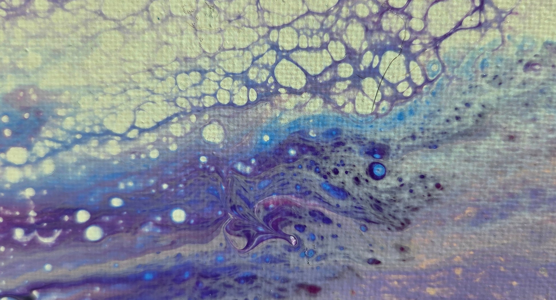 Close-up detail of the lacing of blues and purples over the beige background as well as a gray lacing over turquoise and violet.