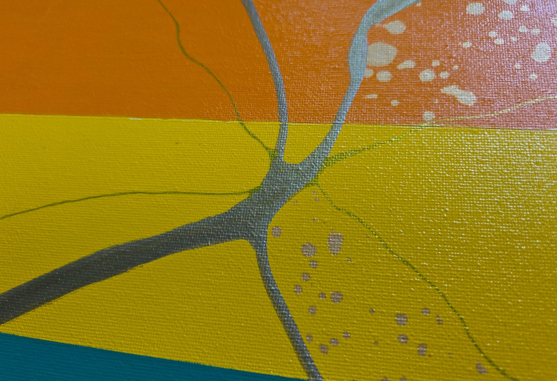 Close up detail of the orange, yellow, and green bands of the pride flag that show the intersection of thick and thin gold lines and the gold speckling.