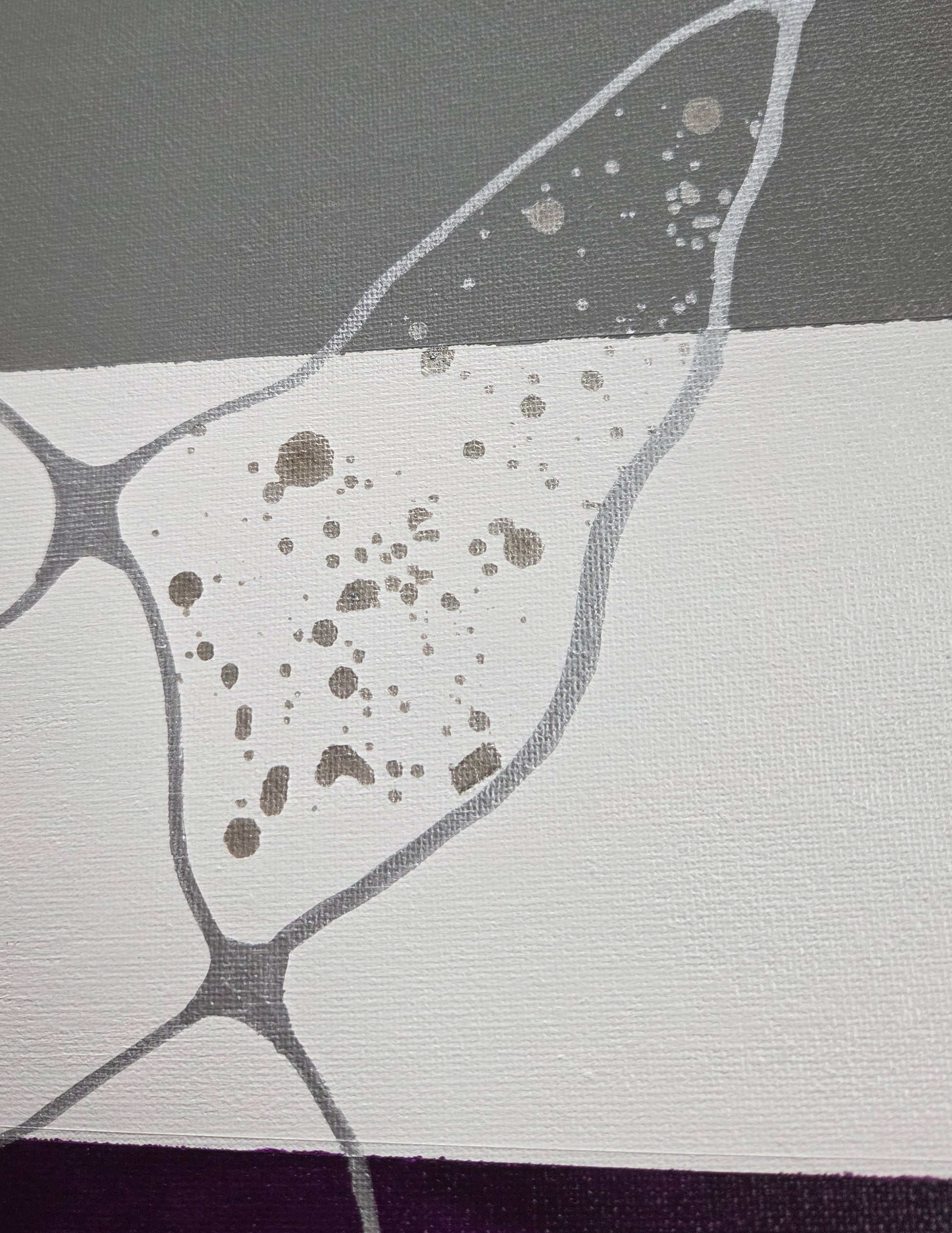 Close up detail of the gray, white, and purple bands of the asexual pride flag showing the oblong space enclosed by silver lines and speckled with silver ink.