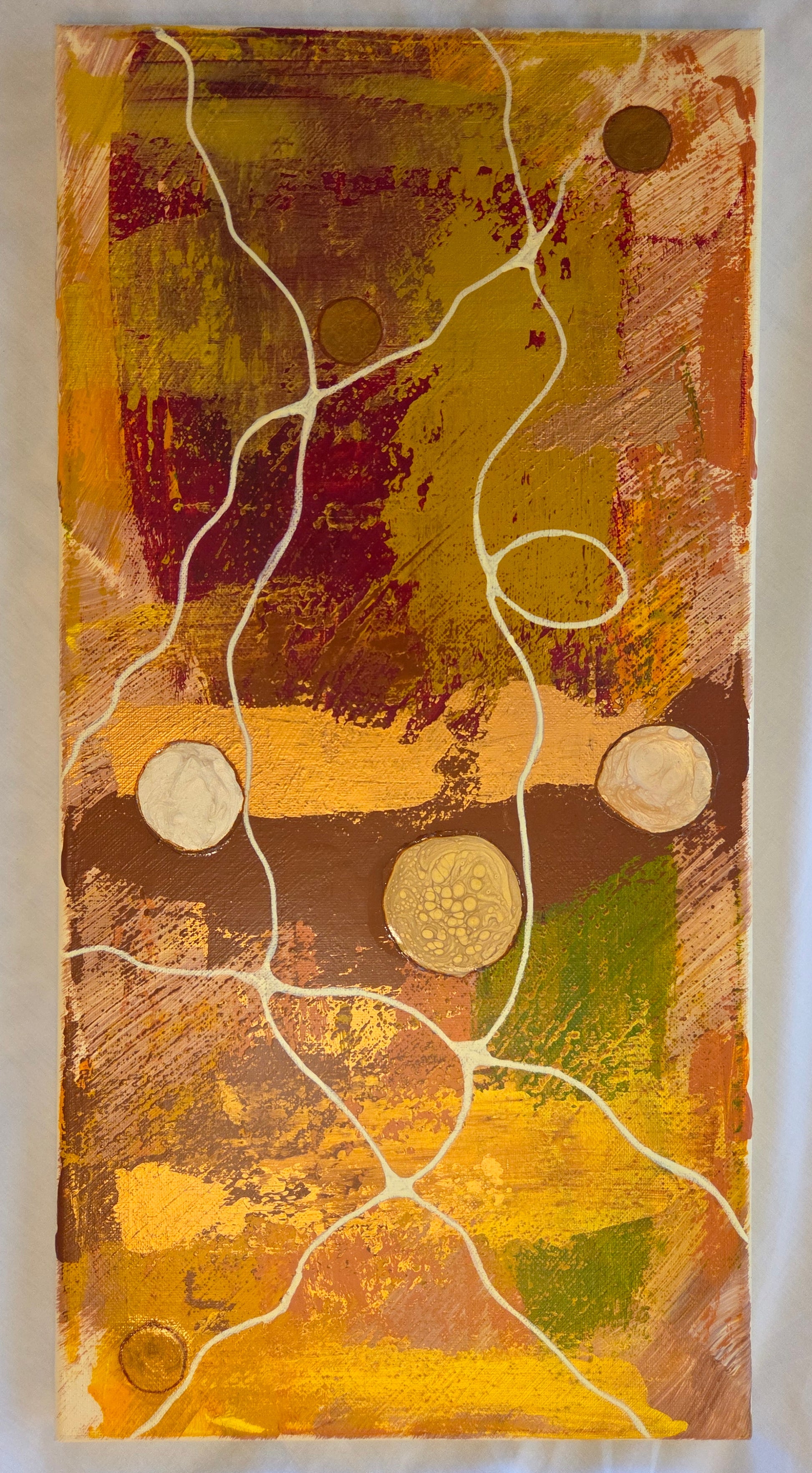 Browns and yellows and reds scraped over a surface with hints of copper, gold, and green. Beige lines interweave like crazy thread, finding the odd copper and ivory button.