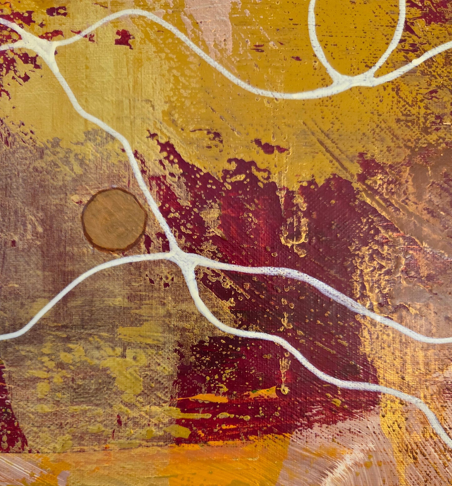 Close-up detail of a portion of red, yellow, and copper paint scraping over each other with the beige thread looping and weaving over it and copper button nestled in place.